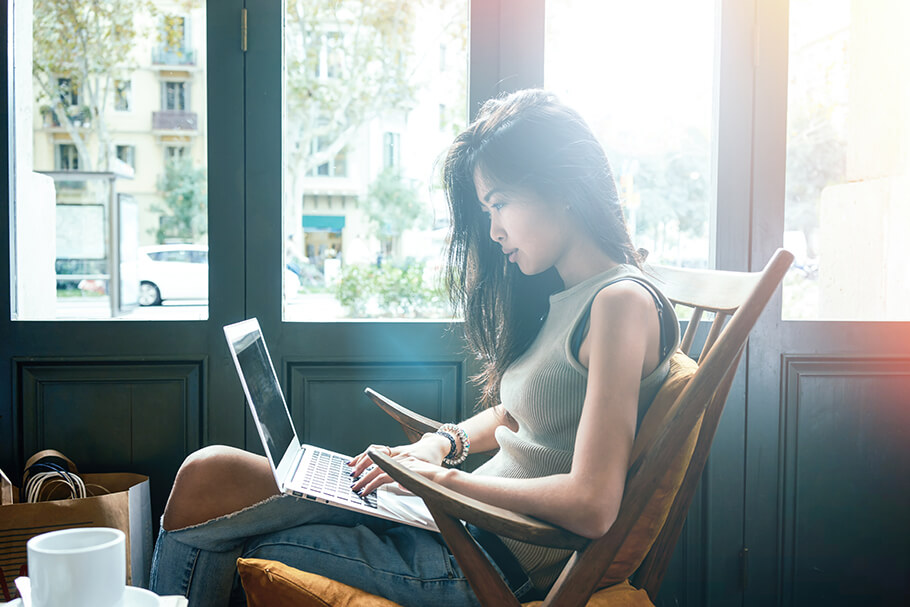 Beautiful young Asian girl working at a coffee shop with a lapto young Asian woman shopping online at a coffee shop with a laptop.