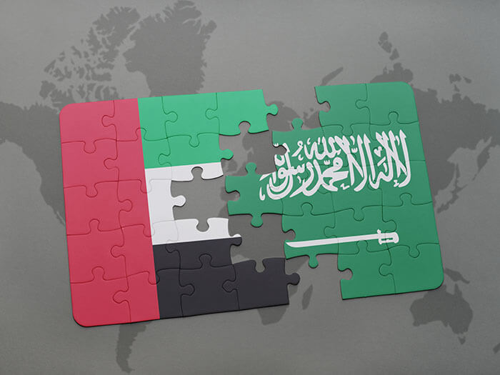 puzzle with the national flag of united arab emirates and saudi arabia on a world map background. saudi arabia uae vat
