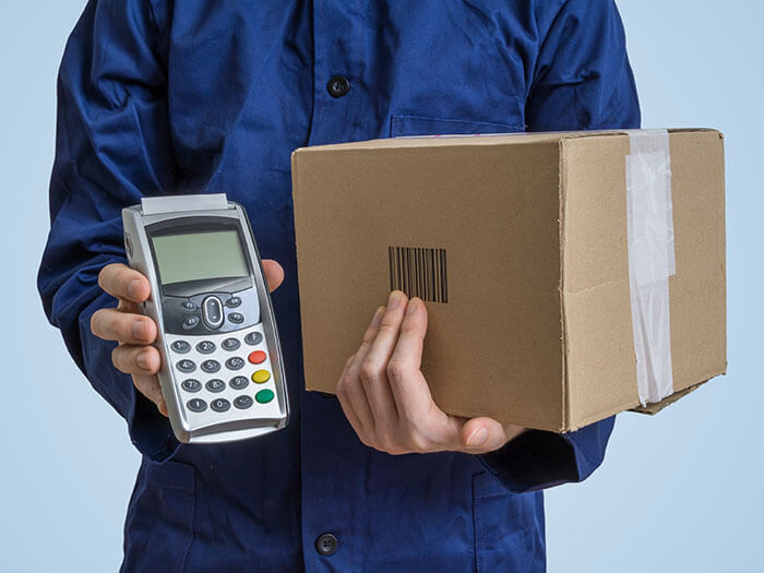 Package delivery concept. Man holds cardboard box and payment te swedish vat